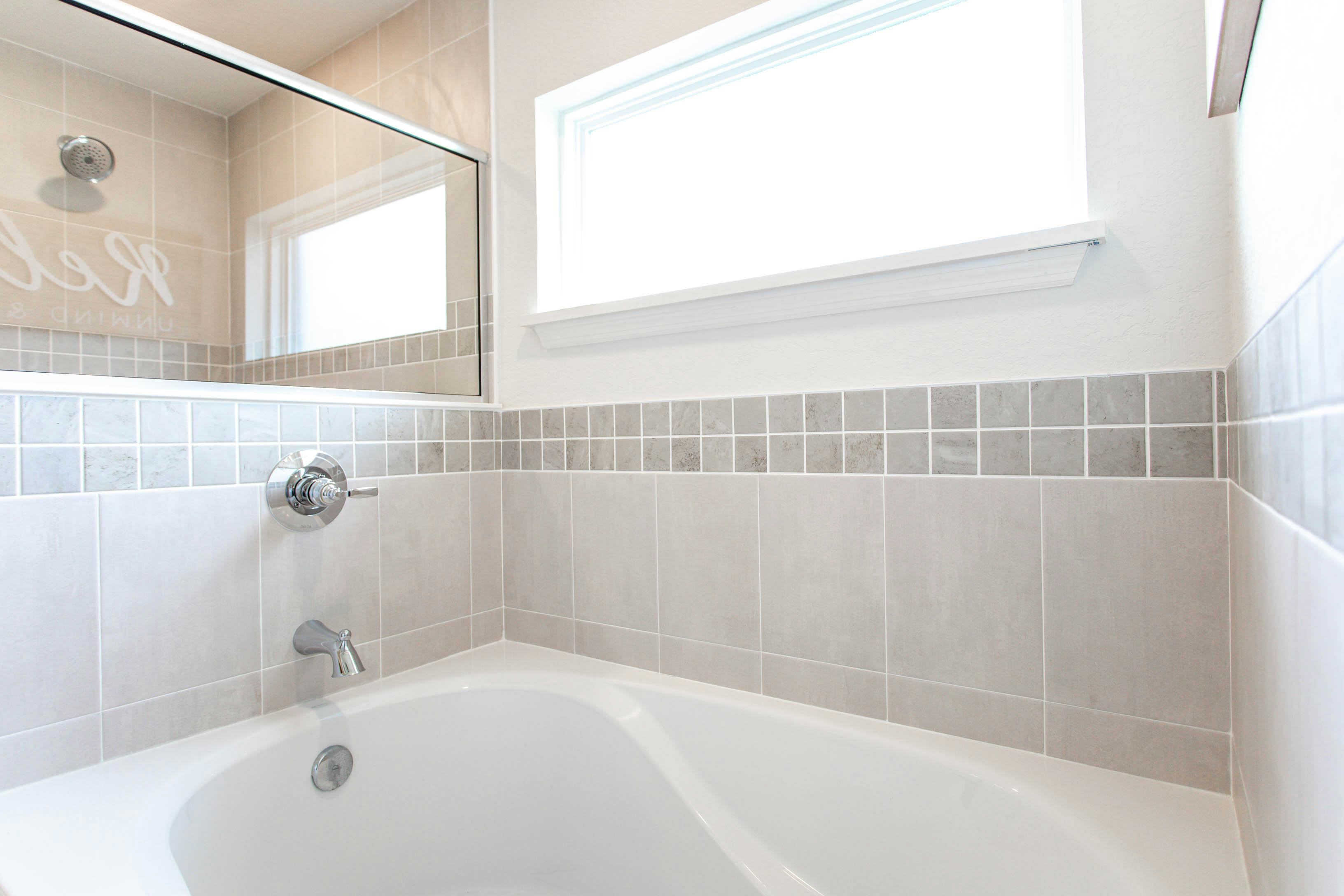 A deep tub with a tiled surround